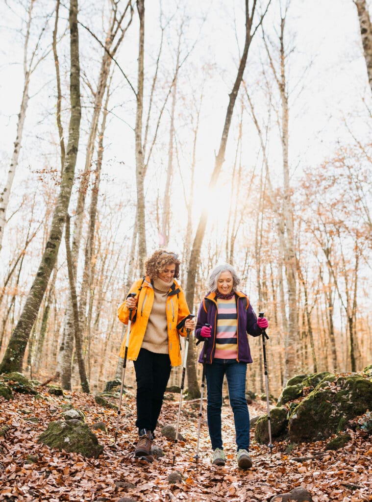 senior friends hiking through the autumn forest